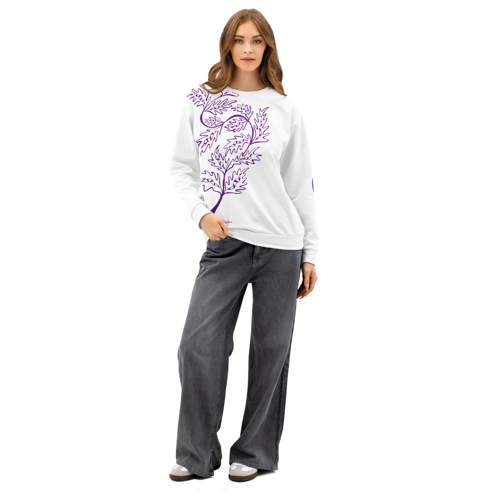 Woman wearing a white sweatshirt with a purple leaf design and gray pants on a white background