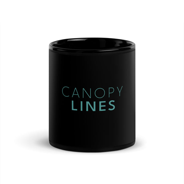 The words CANOPY LINES printed in light teal blue on a black glossy ceramic mug