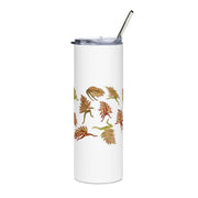 White tumbler with leaf pattern and metal straw on a white background
