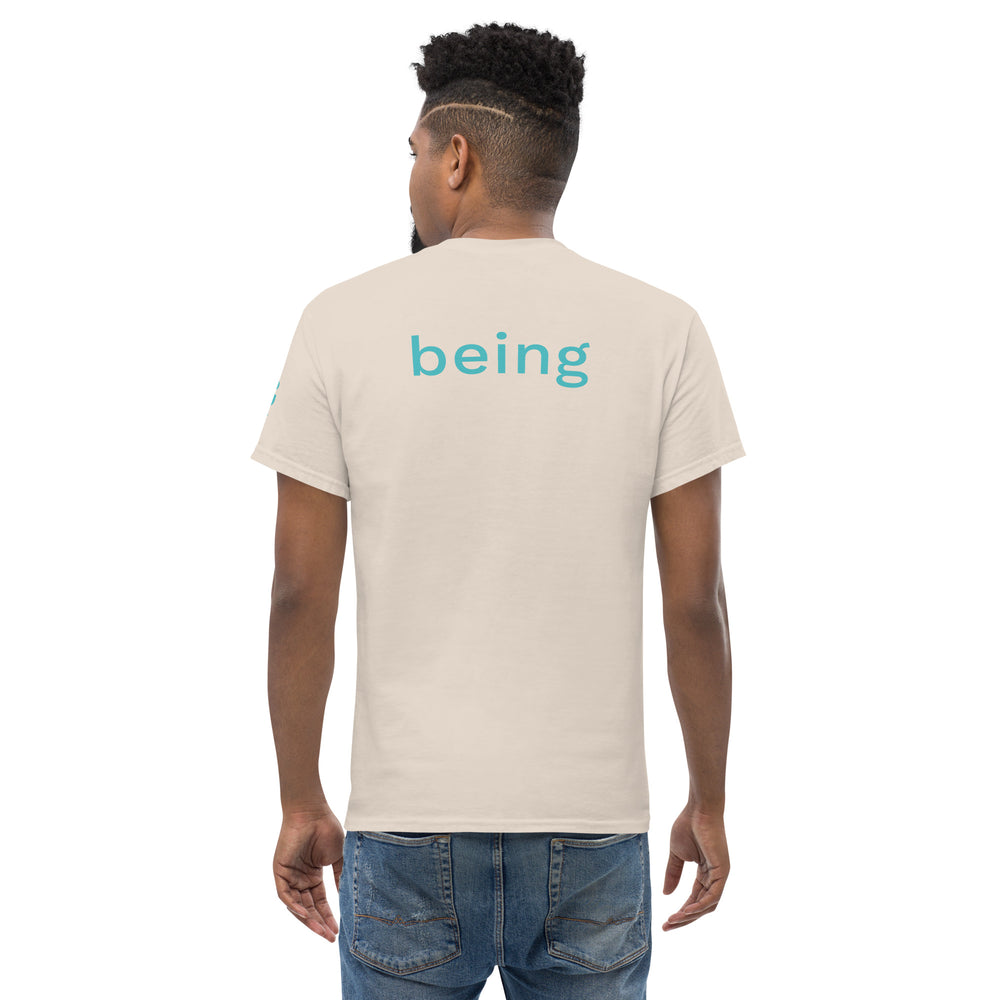 Person wearing a plain beige t-shirt with 'being' printed on the back and blue jeans. 
