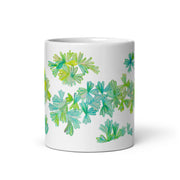 White glossy mug with colorful leaf design on white background