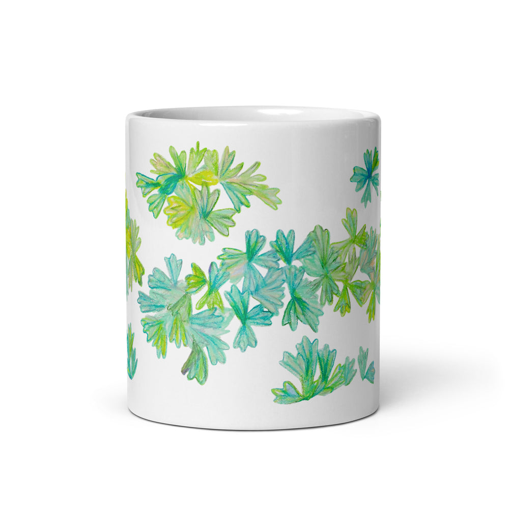 White glossy mug with colorful leaf design on white background