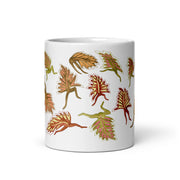 Orange leaves on a white glossy ceramic mug
