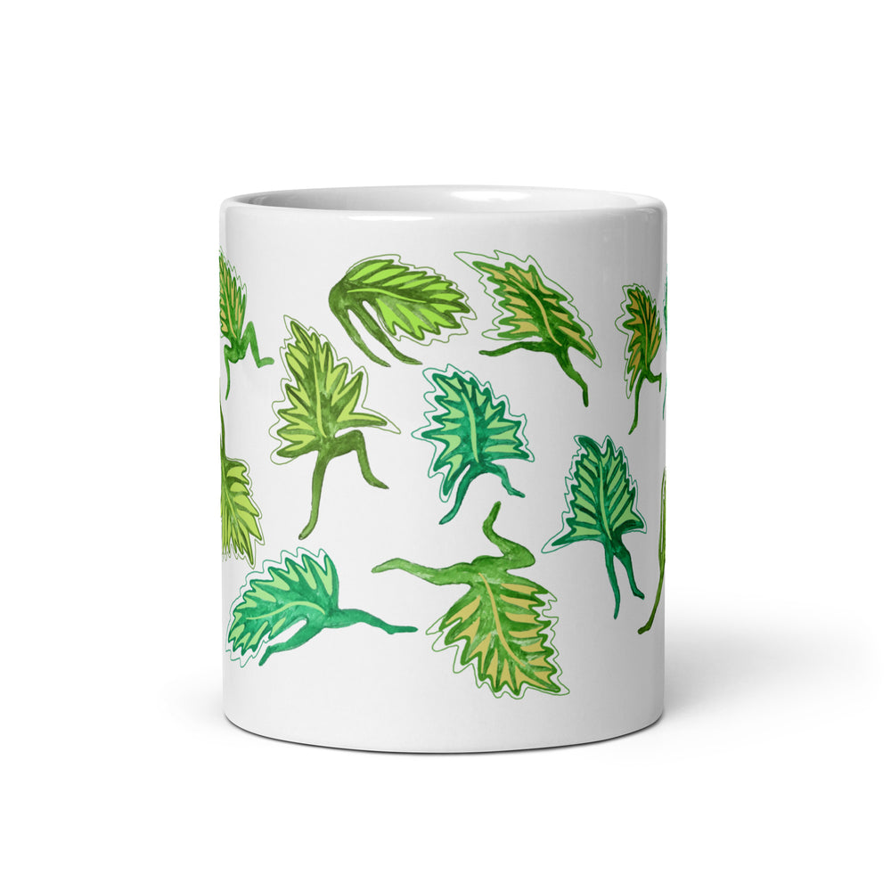 White mug with green leaf patterns on a white background