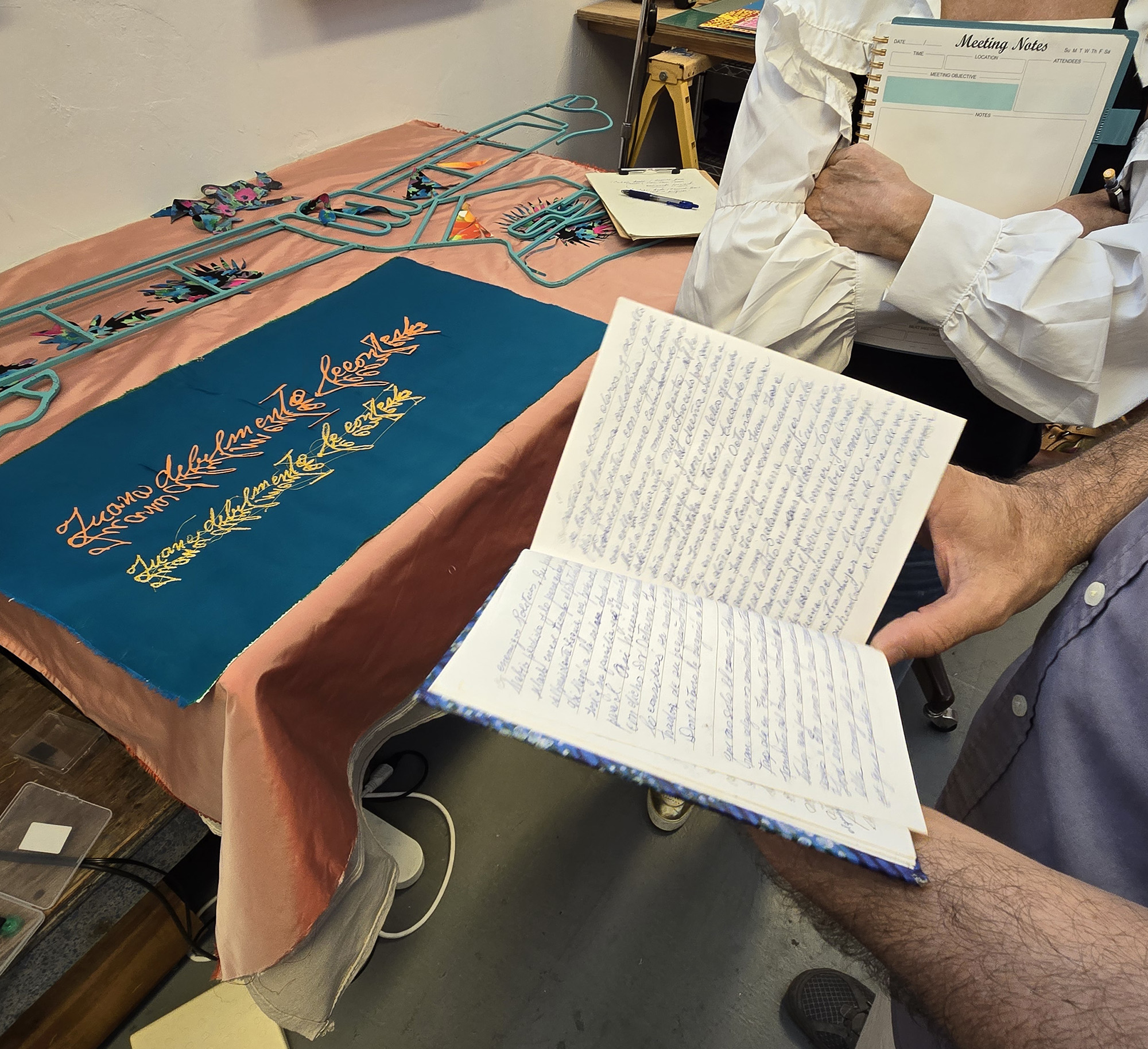 Sterling Rook sharing his Grandmother's sacred journal. Diario Sagrado de las abuelas compartiendo 2025. Bakehouse Art Complex studio, Miami. Photograph by John DeFaro
