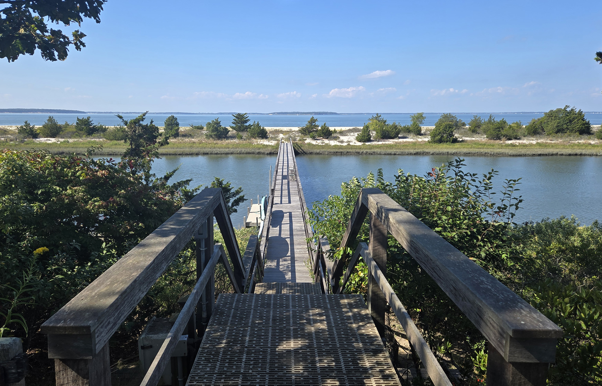 Wooden walking bridge over the coastal creek Cedar Crest North Sea NY photo by John DeFaro
